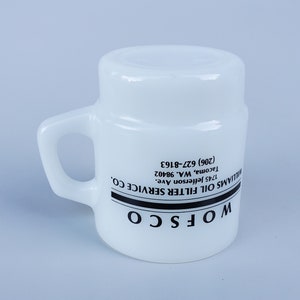 May include: White ceramic mug with a black handle and black text that reads "WOFSCO WILLIAMS OIL FILTER SERVICE CO. 1745 Jefferson Ave. Tacoma, WA. 98402 (206) 627-8163"