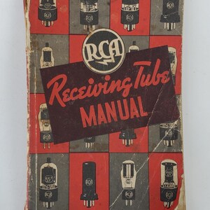 May include: A vintage RCA Receiving Tube Manual, featuring a red and black cover with illustrations of various vacuum tubes. The manual is part of the Technical Series RC-14 and costs 25 cents.
