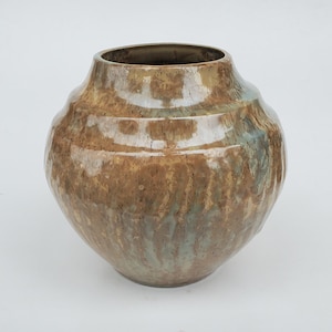 May include: A handcrafted ceramic vase with a wide, rounded body and a narrow opening. The vase features a textured surface with a blend of brown, tan, and teal glaze, creating a unique, earthy aesthetic. The vase is suitable for displaying flowers or as a decorative accent.