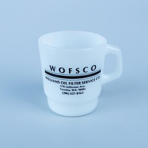 May include: White ceramic mug with black text that reads "WOFSCO WILLIAMS OIL FILTER SERVICE CO. 1745 Jefferson Ave. Tacoma, WA. 98402 (206) 627-8163"