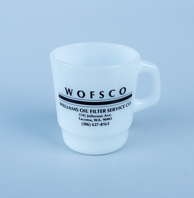 May include: White ceramic mug with black text that reads "WOFSCO WILLIAMS OIL FILTER SERVICE CO. 1745 Jefferson Ave. Tacoma, WA. 98402 (206) 627-8163"