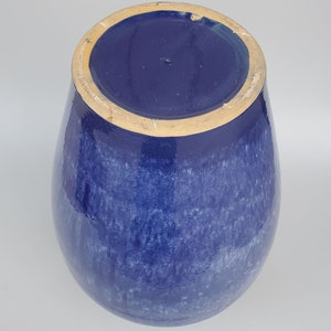 Op de afbeelding: Een blauwe keramische vaas met een gespikkeld glazuur. De vaas heeft een ronde bodem en een brede opening.