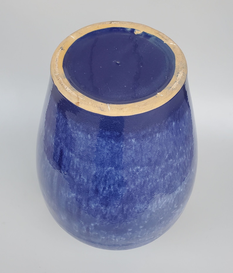 Op de afbeelding: Een blauwe keramische vaas met een gespikkeld glazuur. De vaas heeft een ronde bodem en een brede opening.