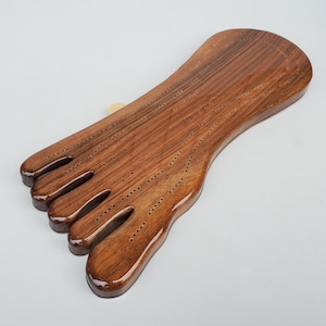 May include: A wooden cribbage board shaped like a foot with a brown stain finish.