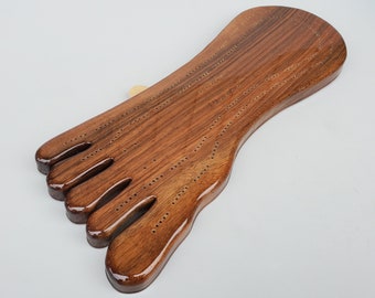 May include: A wooden cribbage board shaped like a foot with a brown stain finish.
