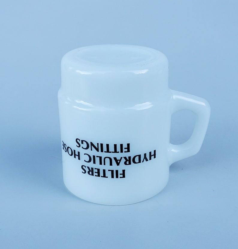 May include: White ceramic mug with black text that reads "FILTERS HYDRAULIC HOSE FITTINGS".