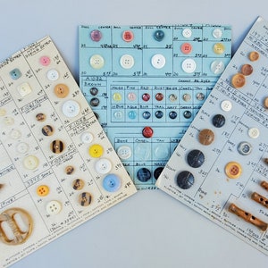 Peut inclure: Trois cartes présentant une sélection de boutons et de boutons à bascule. Les cartes sont étiquetées avec des tailles et des couleurs. Les boutons sont en plastique, en bois et en métal. Les boutons à bascule sont en bois.