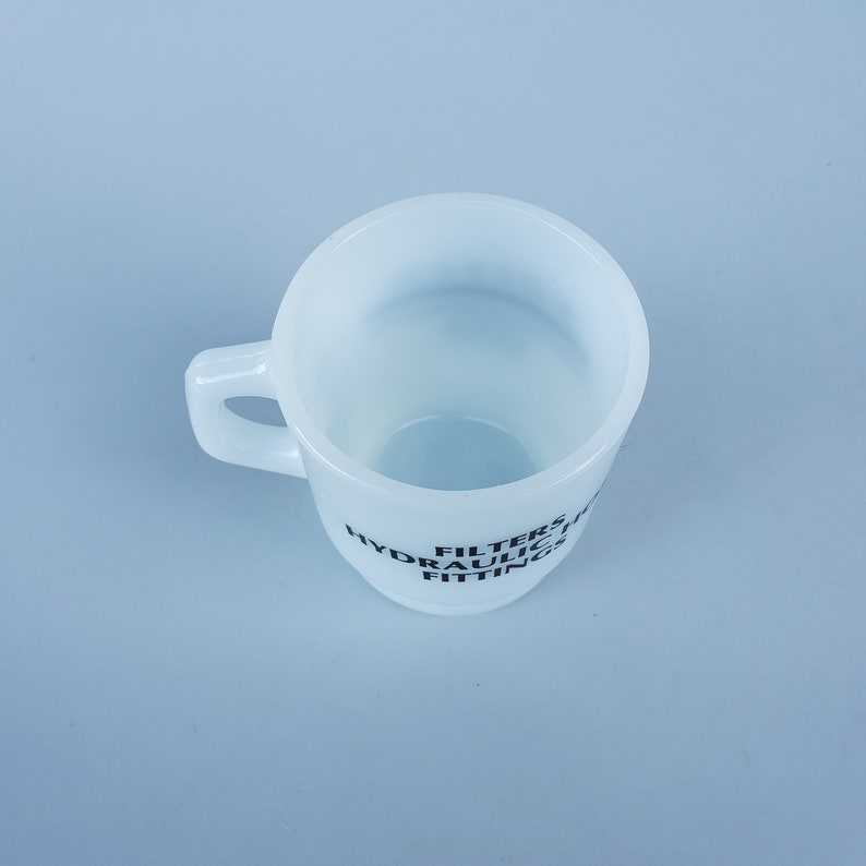 May include: White ceramic mug with black text that reads "FILTERS HYDRAULIC FITTINGS".