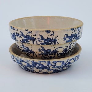 Peut inclure: Deux bols en céramique avec un motif moucheté bleu et blanc. Les bols sont emboîtés l'un dans l'autre.