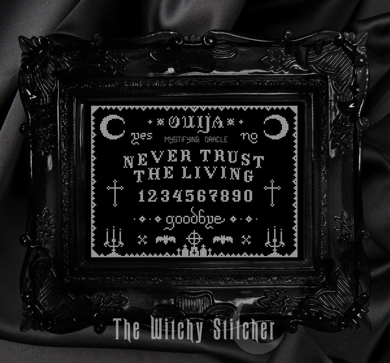 Puede incluir: Una imagen enmarcada en negro con un dise&ntilde;o de tablero de Ouija bordado en blanco. El tablero presenta las letras del alfabeto, los n&uacute;meros del 1 al 10, y las palabras "s&iacute;", "no", "adi&oacute;s", y "NUNCA CONFIES EN LOS VIVOS".