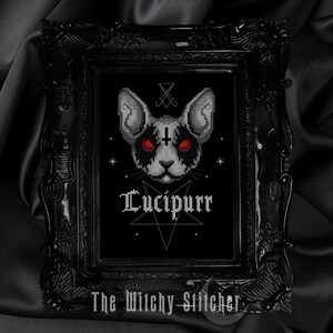 K&ouml;nnte beinhalten: Schwarzwei&szlig;es Kreuzstichmuster eines Katers mit roten Augen, einem Pentagramm und dem Text "Lucipurr". Das Design ist in einem schwarzen Rahmen mit schwarzem Hintergrund gerahmt.