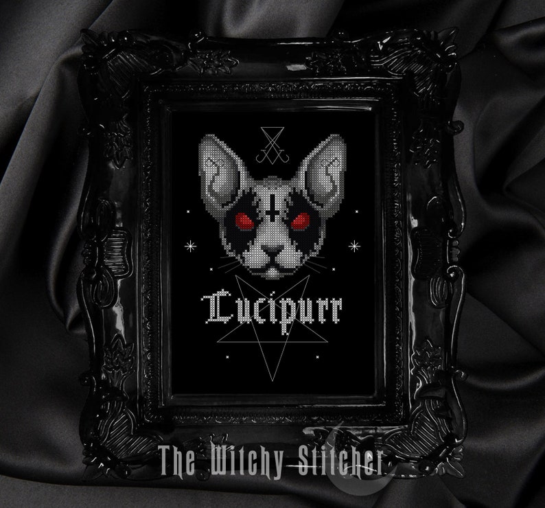 K&ouml;nnte beinhalten: Schwarzwei&szlig;es Kreuzstichmuster eines Katers mit roten Augen, einem Pentagramm und dem Text "Lucipurr". Das Design ist in einem schwarzen Rahmen mit schwarzem Hintergrund gerahmt.