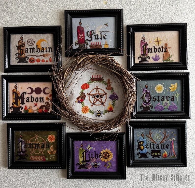 May include: Eight framed cross-stitch embroideries arranged around a central twig wreath. Each piece features a seasonal theme with text including Samhain, Yule, Imbolc, Mabon, Ostara, Lammas, Litha, and Beltane, accompanied by candles and symbols.