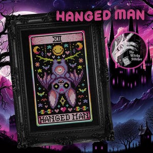 May include: A black framed cross-stitch pattern of the Hanged Man tarot card featuring a purple bat with a pink face and rainbow accents. The card is set against a black background with a pink border and the text "Hanged Man" at the bottom.
