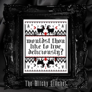 May include: Black framed cross-stitch art with the text "Wouldst thou like to live deliciously?" in red and black. The design includes black goats, moons, and other symbols. The Witchy Stitcher is printed at the bottom.