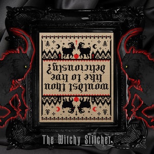 May include: A framed cross-stitch piece with a black frame. The cross-stitch features black goats, moons, and the text "Wouldst thou like to live deliciously?" in red and black. The words "The Witchy Stitcher" are at the bottom.