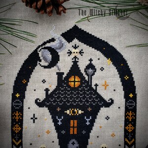 May include: Cross stitch pattern featuring a black and gray spooky house with a yellow window, a crescent moon, and stars. The pattern is on a beige linen fabric. The text "The Witchy Stitcher" is in the top right corner.