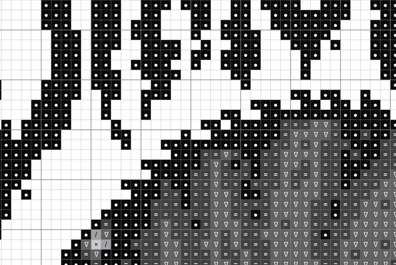 May include: A black and white cross stitch pattern printed on a grid. The design features solid black blocks forming shapes and a grey shaded area filled with various symbols including triangles, equals signs, dots, and slashes for embroidery guidance.