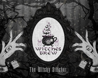 May include: A cross-stitch pattern featuring a black cauldron with a skull, bats, and rising steam, centered in an ornate oval frame. The text Witches Brew is stitched below the cauldron. Two illustrated hands with tattoos flank the frame.