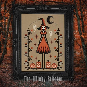 May include: Cross-stitch artwork in a black frame featuring a witch with a tall hat and orange dress, surrounded by ghosts, pumpkins, and a crescent moon. The text "The Witchy Stitcher" is at the bottom. The artwork has a fall theme.