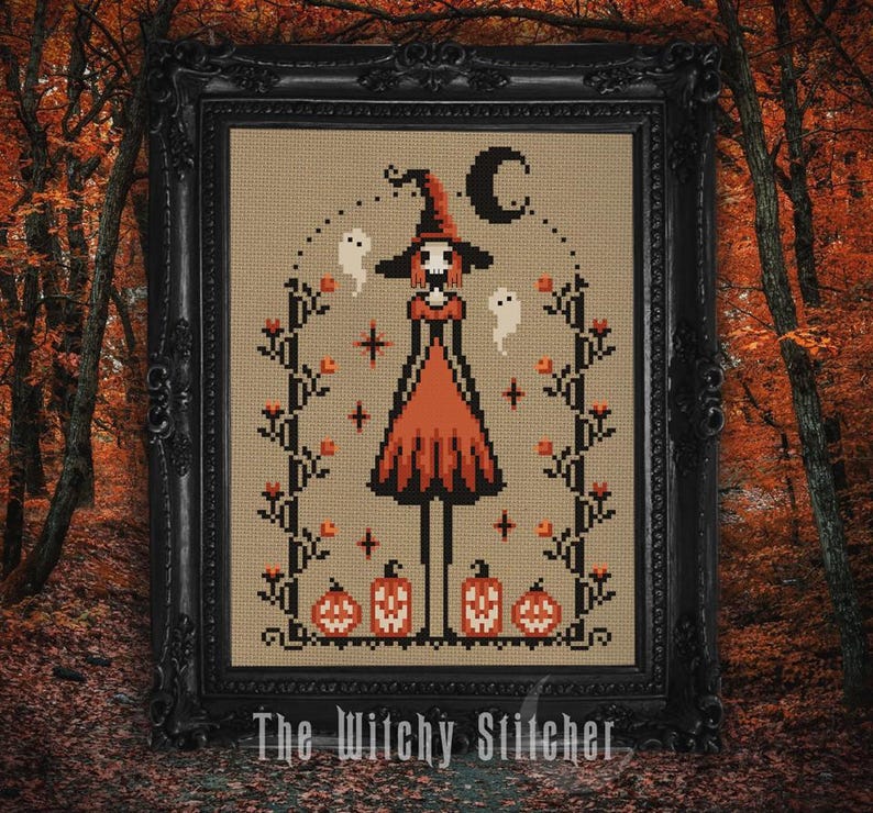 May include: Cross-stitch artwork in a black frame featuring a witch with a tall hat and orange dress, surrounded by ghosts, pumpkins, and a crescent moon. The text "The Witchy Stitcher" is at the bottom. The artwork has a fall theme.