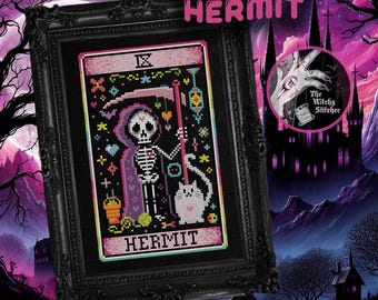 May include: A framed cross-stitch art piece titled HERMIT featuring a skeleton in a purple hooded cloak holding a scythe, accompanied by a white cat. The design includes colorful geometric accents on a black background, all encased in a black ornate frame.