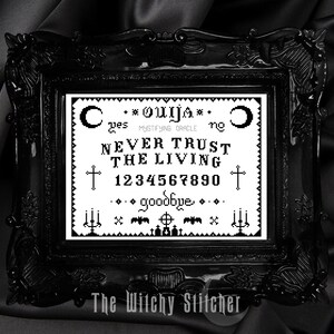 Puede incluir: Imagen en blanco y negro de una tabla Ouija con el texto "Ces * OUIJA * ne NEVER TRUST THE LIVING &dagger; 1234567890 &dagger; ...goodbye..." en un marco negro con el texto "The Witchy Stitcher" en la parte inferior.