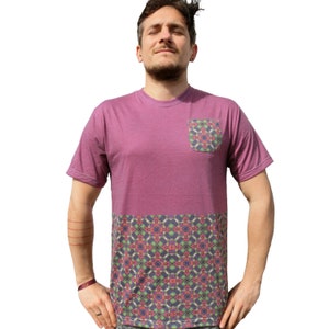 Può includere: Una maglietta viola con una tasca a fantasia e una metà inferiore con un motivo geometrico colorato.