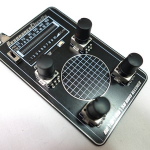 May include: A black circuit board labeled "Resonance Circuits" with a grid and several knobs. The board has a frequency scale and the text "SW Radio Receiver".