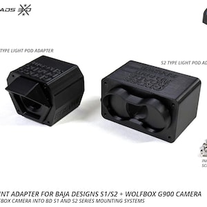 May include: Black S1 and S2 type light pod adapters. The adapters are designed to mount a Wolfbox camera into BD S1 and S2 series mounting systems. Includes stainless screws and O-rings. The text "Crossroads EXO" is visible on the adapters. Made in the USA.