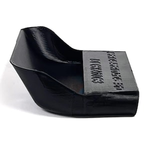 Può includere: Un oggetto nero e angolare con finitura lucida. L'oggetto ha un retro curvo e una sezione frontale piatta e rettangolare. La sezione frontale presenta il testo "D1GX460C3" e un'altra riga di testo. L'oggetto è posto su uno sfondo bianco.