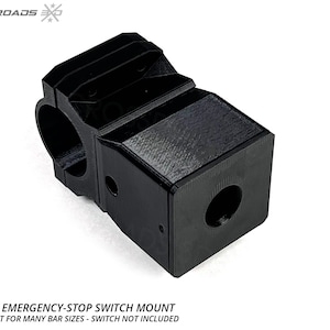 Peut inclure: Support de commutateur d'arrêt d'urgence de barre de sécurité noir. Le support est conçu avec précision pour de nombreuses tailles de barres. Le texte "ROLL-BAR EMERGENCY-STOP SWITCH MOUNT" est visible. Fabriqué aux États-Unis.