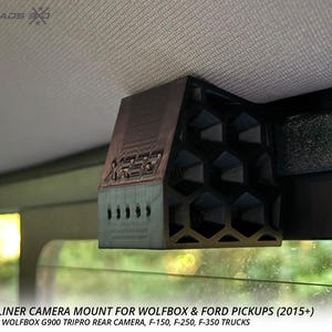 May include: A black and brown rear headliner camera mount with a honeycomb design. The mount is designed for Wolfbox and Ford pickup trucks. The text "CROSSROADS" is visible at the top left.