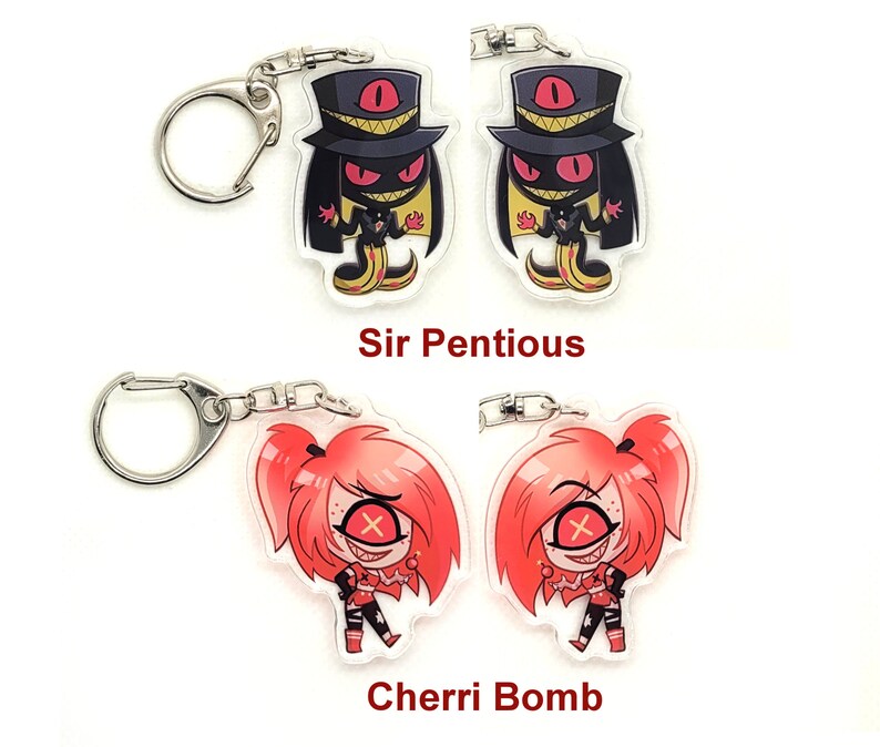 Puede incluir: Dos juegos de llaveros con personajes de la serie animada Hazbin Hotel. El primer juego presenta a Sir Pentious, un demonio serpiente negro y amarillo con un sombrero de copa y un solo ojo. El segundo juego presenta a Cherri Bomb, un demonio de cabello rojo con un vestido rojo y una cruz roja sobre su ojo.