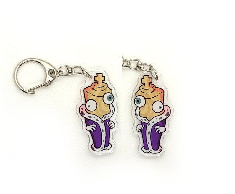 May include: Two purple and gold chess piece keychain charms with a crown and a face. The charms are attached to silver keychains.