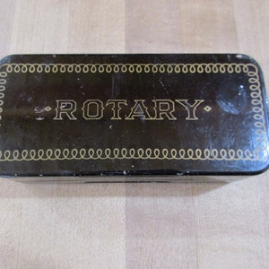 May include: A black metal box with a gold border and the word "ROTARY" printed in gold letters.