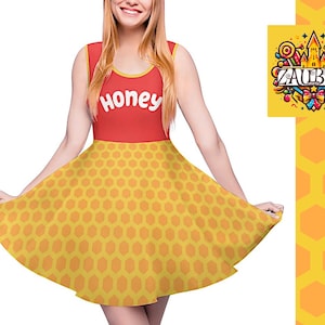 Puede incluir: Un vestido amarillo y rojo con una falda de patrón de panal y la palabra "Honey" impresa en el corpiño. El vestido es sin mangas y tiene una falda de estilo patinadora.