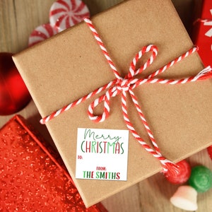 May include: A brown gift box with a red and white twine bow. A white gift tag with green and red lettering reads "Merry Christmas" and "From: The Smiths".