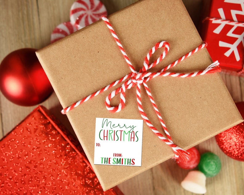 May include: A brown gift box with a red and white twine bow. A white gift tag with green and red lettering reads "Merry Christmas" and "From: The Smiths".