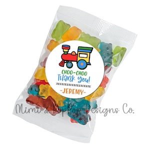 May include: A clear plastic bag filled with colorful gummy bears. A round sticker with a cartoon train and the text "Choo-choo Thank you! -JEREMY- " is attached to the bag.