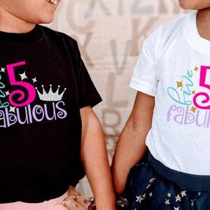 May include: Two children wearing matching shirts with the text "Five Fabulous" and a pink number 5, a crown, and glitter accents. The shirts are black and white.
