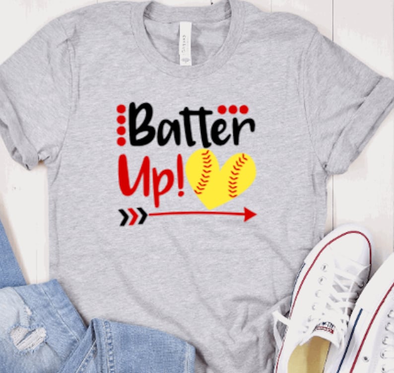 May include: Gray t-shirt with the text "Batter Up!" in black and red, featuring a yellow softball in a heart shape with red stitching.