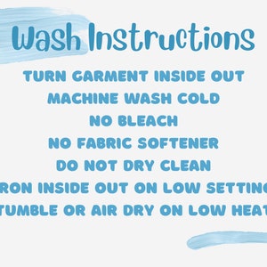 May include: Blue text on a white background with instructions for washing a garment. The text reads: "Wash Instructions", "Turn garment inside out", "Machine wash cold", "No bleach", "No fabric softener", "Do not dry clean", "Iron inside out on low setting", "Tumble or air dry on low heat".