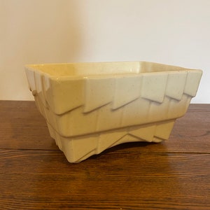 以下が含まれることがあります： 幾何学模様の白いセラミック製のプランター。プランターは長方形で、底がわずかに湾曲している。