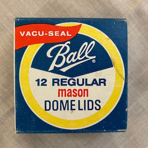 May include: A blue and yellow box with a red and white circle containing the text "VACU-SEAL Ball" and "12 REGULAR mason DOME LIDS".