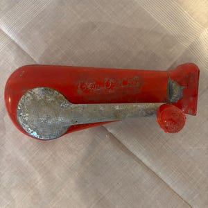May include: Red and silver can opener with the words "Can-O-Matic" printed on the side.