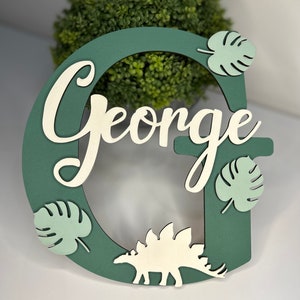 Letrero de dinosaurio para puerta. Letrero para puerta de dormitorio. Letra inicial de madera. Nombre para caja de juguetes. Placa para puerta. Regalo de bautizo. Letrero de dinosaurio para puerta. 20 cm.