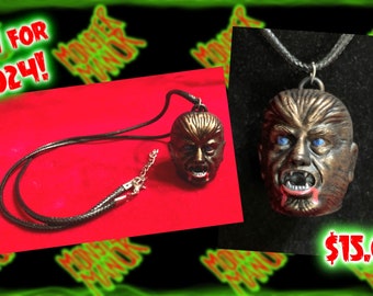 May include: A black cord necklace with a werewolf head pendant. The pendant is made of a dark brown material and has blue eyes. The pendant is dripping with red paint. The text "$15.00" is visible in the image.