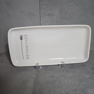May include: A rectangular white ceramic serving platter with rounded corners. A black and white botanical illustration and text are on the left side. The text includes words like "treasure" and "complete".