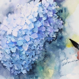 May include: A watercolor painting of a blue and purple hydrangea flower. The flower is painted in a loose, impressionistic style, with soft edges and subtle color variations. The background is a soft wash of blue and green.